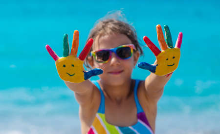 Child hands painted with paints on the sea. Selective focus. Kid.の写真素材