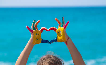 Child hands painted with paints on the sea. Selective focus. Kid.の写真素材