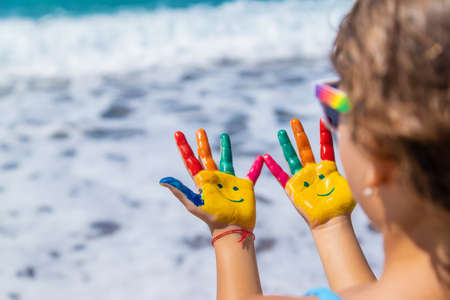 Child hands painted with paints on the sea. Selective focus. Kid.の写真素材