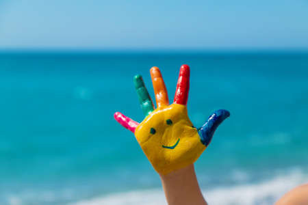 Child hands painted with paints on the sea. Selective focus. Kid.の写真素材