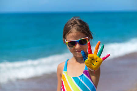 Child hands painted with paints on the sea. Selective focus. Kid.の写真素材