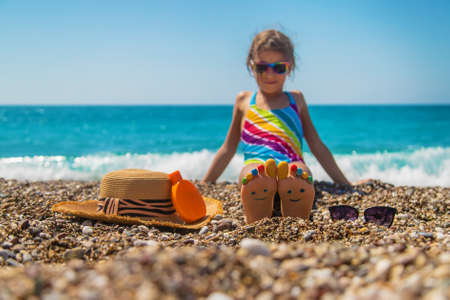 Child feet painted with paints on the sea. Selective focus. Kid.の写真素材