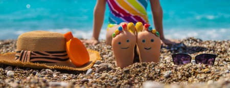 Child feet painted with paints on the sea. Selective focus. Kid.の写真素材