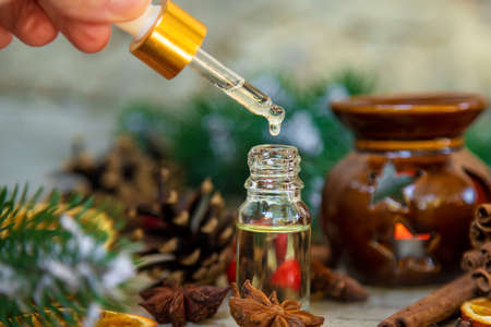 Christmas essential oils in small bottles. Selective focus. Nature.