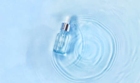 Cosmetics in a bottle in water, skin hydration concept. Hyaluronic acid. Selective focus. Nature.の写真素材