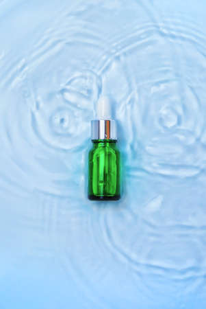Cosmetics in a bottle in water, skin hydration concept. Hyaluronic acid. Selective focus. Nature.の写真素材