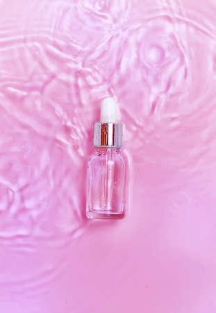 Cosmetics in a bottle in water, skin hydration concept. Hyaluronic acid. Selective focus. Nature.の写真素材