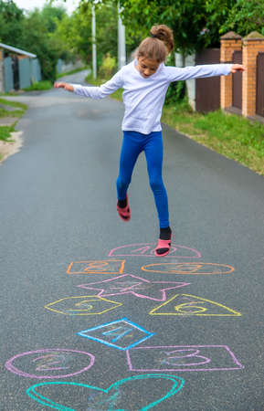 Child jumping classics on the street. Selective focus. Kid.の写真素材