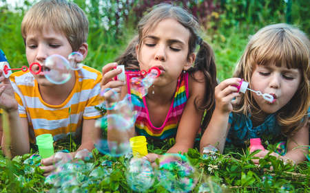 Children blow bubbles in the street. Selective focus. nature.