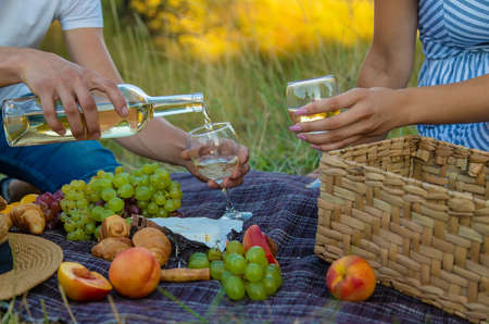 A man and a woman are drinking wine at a picnic. Selective focus. Nature.の写真素材