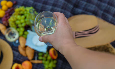 The girl pours wine at a picnic. Selective focus. Nature.