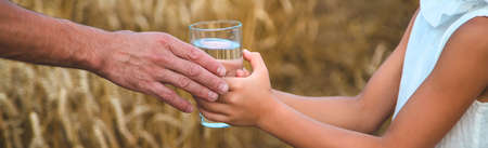 Father and child with a glass of water. Selective focus. Kid.の写真素材