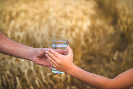 Father and child with a glass of water. Selective focus. Kid.の写真素材