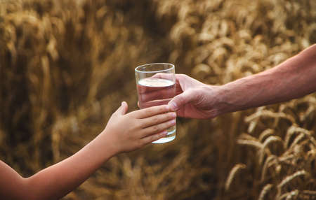 Father and child with a glass of water. Selective focus. Kid.の写真素材