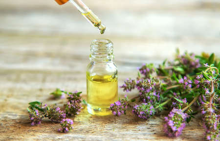 Thyme essential oil in a small bottle. Selective focus. Nature.の写真素材