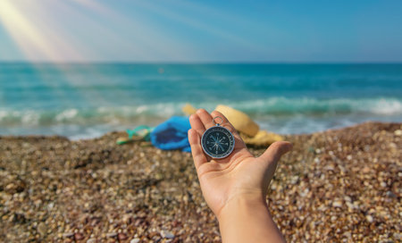 Compass in hands against the background of the sea. Selective focus. Travel.の写真素材
