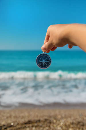 Compass in hands against the background of the sea. Selective focus. Travel.の写真素材