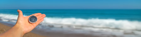 Compass in hands against the background of the sea. Selective focus. Travel.の写真素材