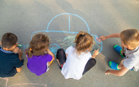children draw a car with chalk on the pavement. selective focus. nature.の写真素材