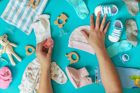 Baby clothes and accessories on the blue background. Selective focus. Nature.