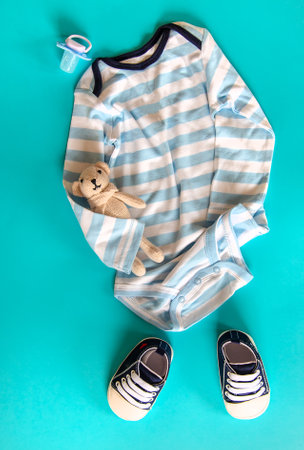 Baby clothes and accessories on the blue background. Selective focus. Nature.