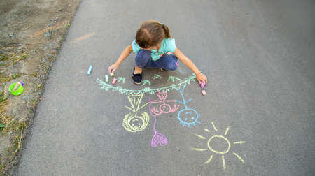 The child draws a family on the asf. Selective focus. Kid.の写真素材