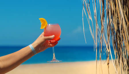 Woman on the beach holding a cocktail in her hands. Selective focus. Drink.の写真素材