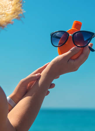 Sunscreen in the hands of a woman. Selective focus. Nature.の写真素材