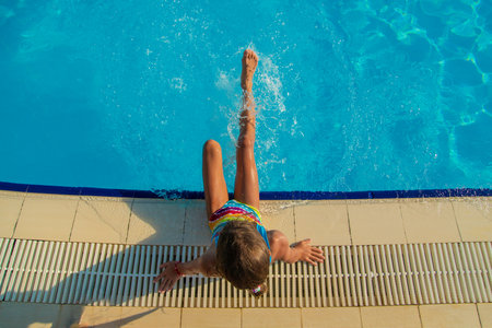 The child splashes his feet near the pool. Selective focus. Kid.の写真素材