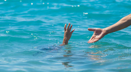The child is drowning in the water the hand of salvation. Selective focus. People.の写真素材