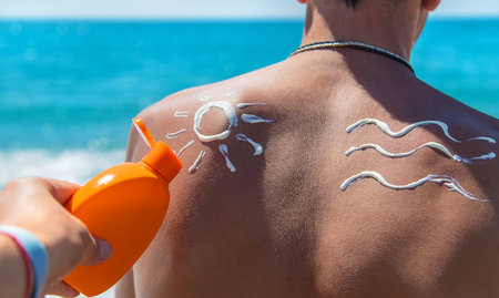 Sunscreen on the man back. Selective focus. People.の写真素材
