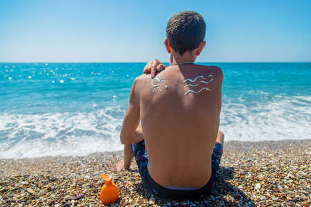 Sunscreen on the man back. Selective focus. People.