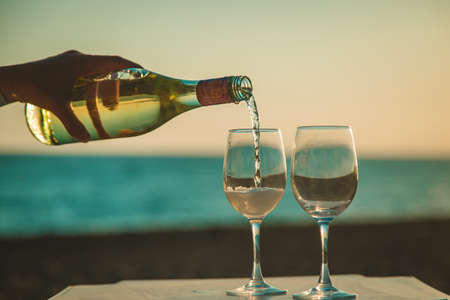 Wine glasses at sunset on the beach. Selective focus. Nature.の写真素材