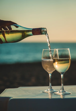 Wine glasses at sunset on the beach. Selective focus. Nature.の写真素材