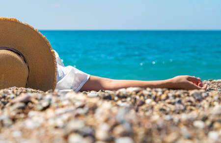 Woman with hat on the beach. Selective focus. Sea.の写真素材