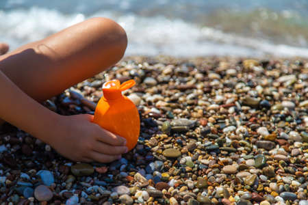 Sunscreen in hands on the beach. Selective focus. Sea.の写真素材