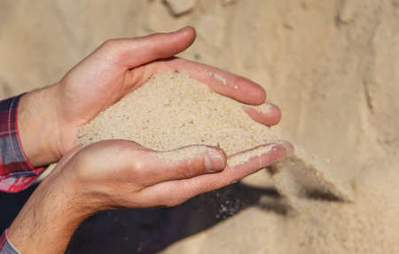 Sand quarry in the hands of a man. Selective focus. Nature.