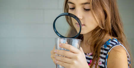 Children look at the water with a magnifying glass. Selective focus. Kid.