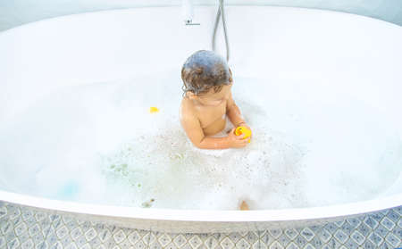 A child bathes in a bubble bath. selective focus. Happy.の写真素材