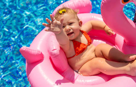 Baby swims in a circle in the pool. Selective focus.の写真素材