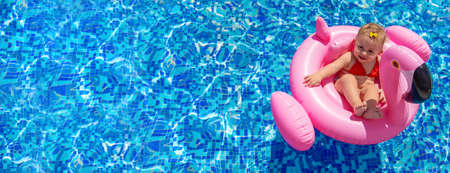 Baby swims in a circle in the pool. Selective focus.