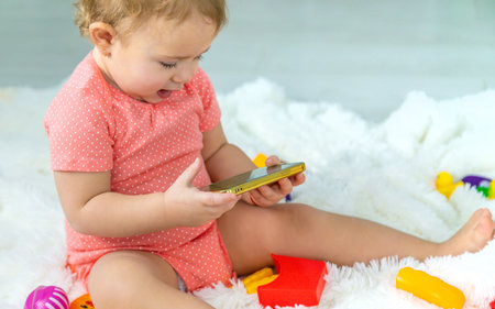 Baby is playing on the phone. selective focus. kid.