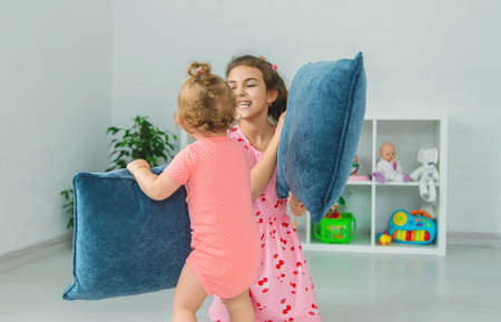 Children beat pillows in the room. selective focus. child.の写真素材