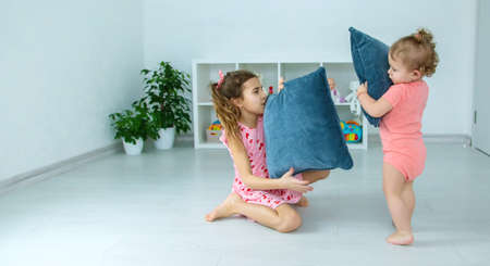 Children beat pillows in the room. selective focus. child.の写真素材
