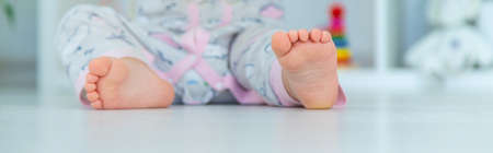 The baby's feet are sitting on the floor. selective focus. child.