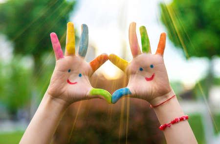Hands of a child with a drawn emoticon. selective focus.の写真素材