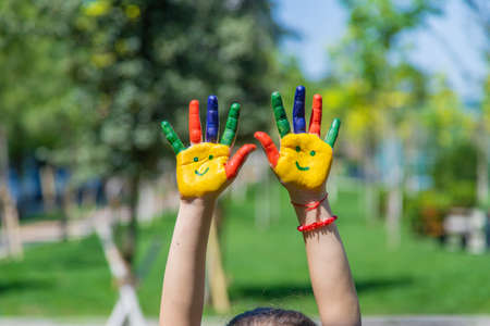Hands of a child with a painted smile. selective focus. hands.の写真素材