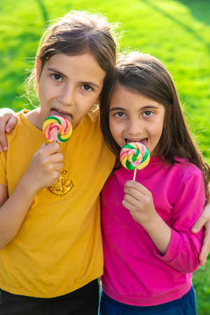A child eats a lollipop in the park. selective focus. kd.の写真素材