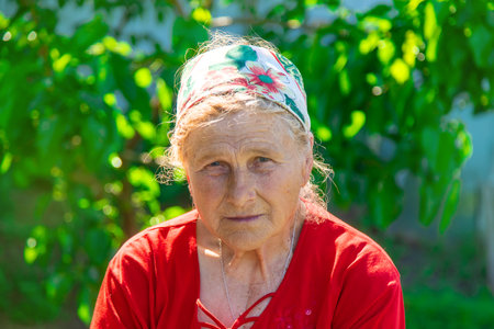 Portrait of an old woman in the garden. Selective focus.の写真素材