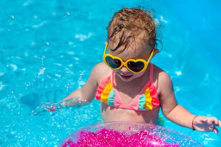 A child swims in a pool with a circle. Selection focus.の写真素材